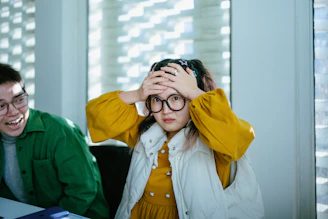 a boy and a girl sitting at a table with a laptop