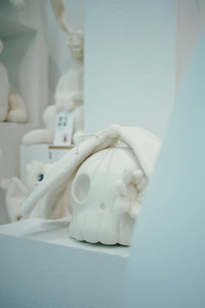 Elegant display of several artisan skulls arranged in a minimalist gallery setting with soft desert sand tones.