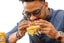 A happy customer enjoying a delicious burger at eai primos.