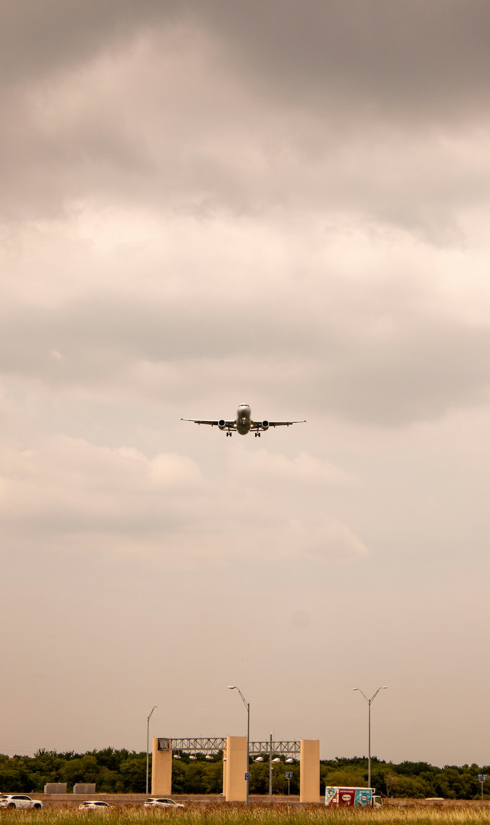 an airplane is flying over a field of grass