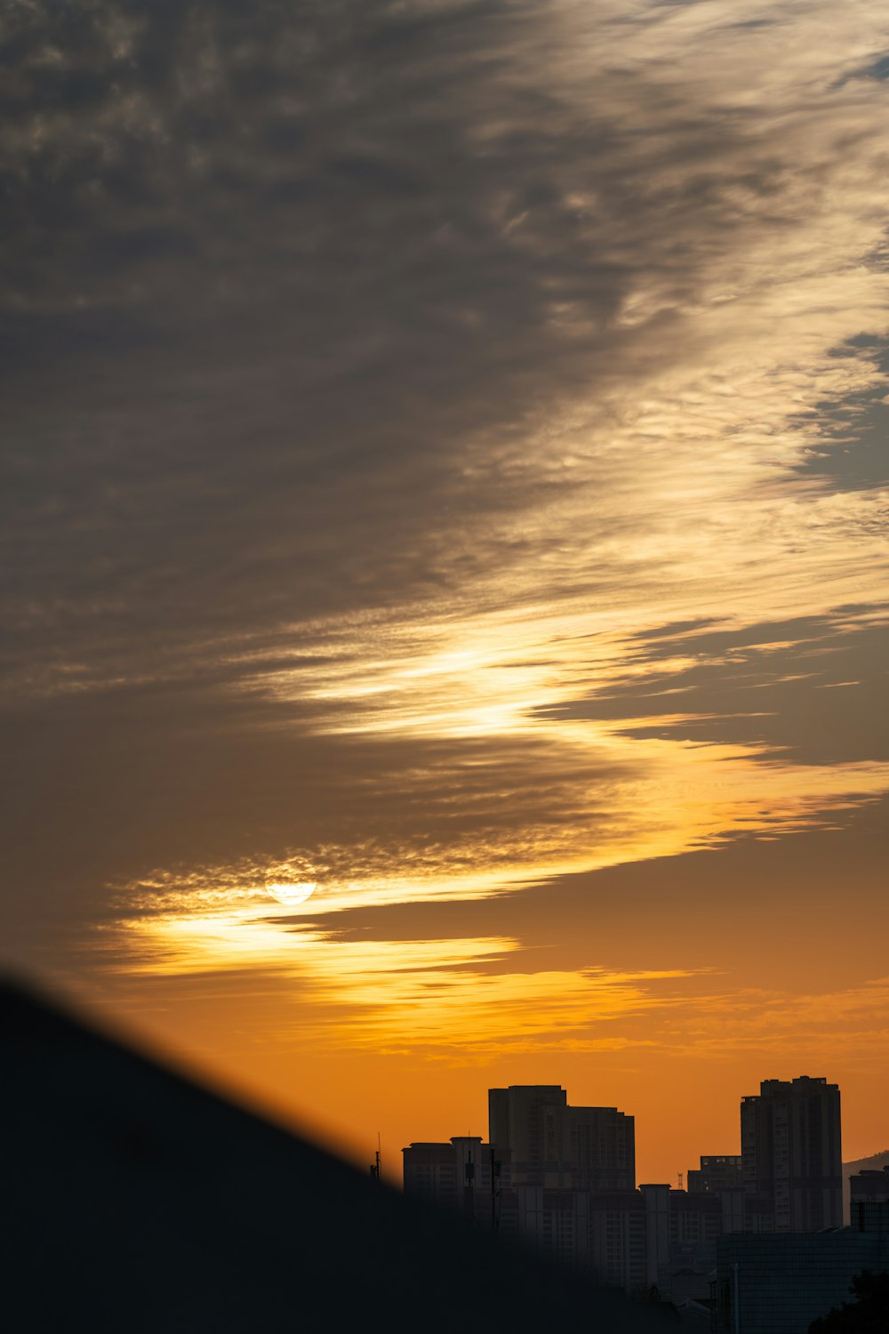 the sun is setting over a city with tall buildings