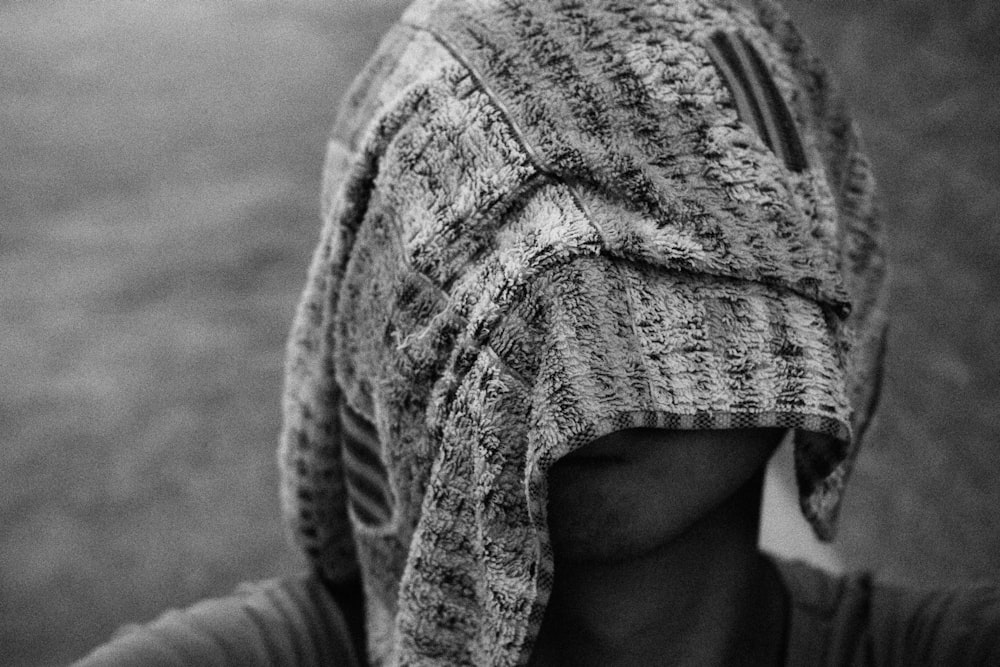 a black and white photo of a woman with a scarf on her head