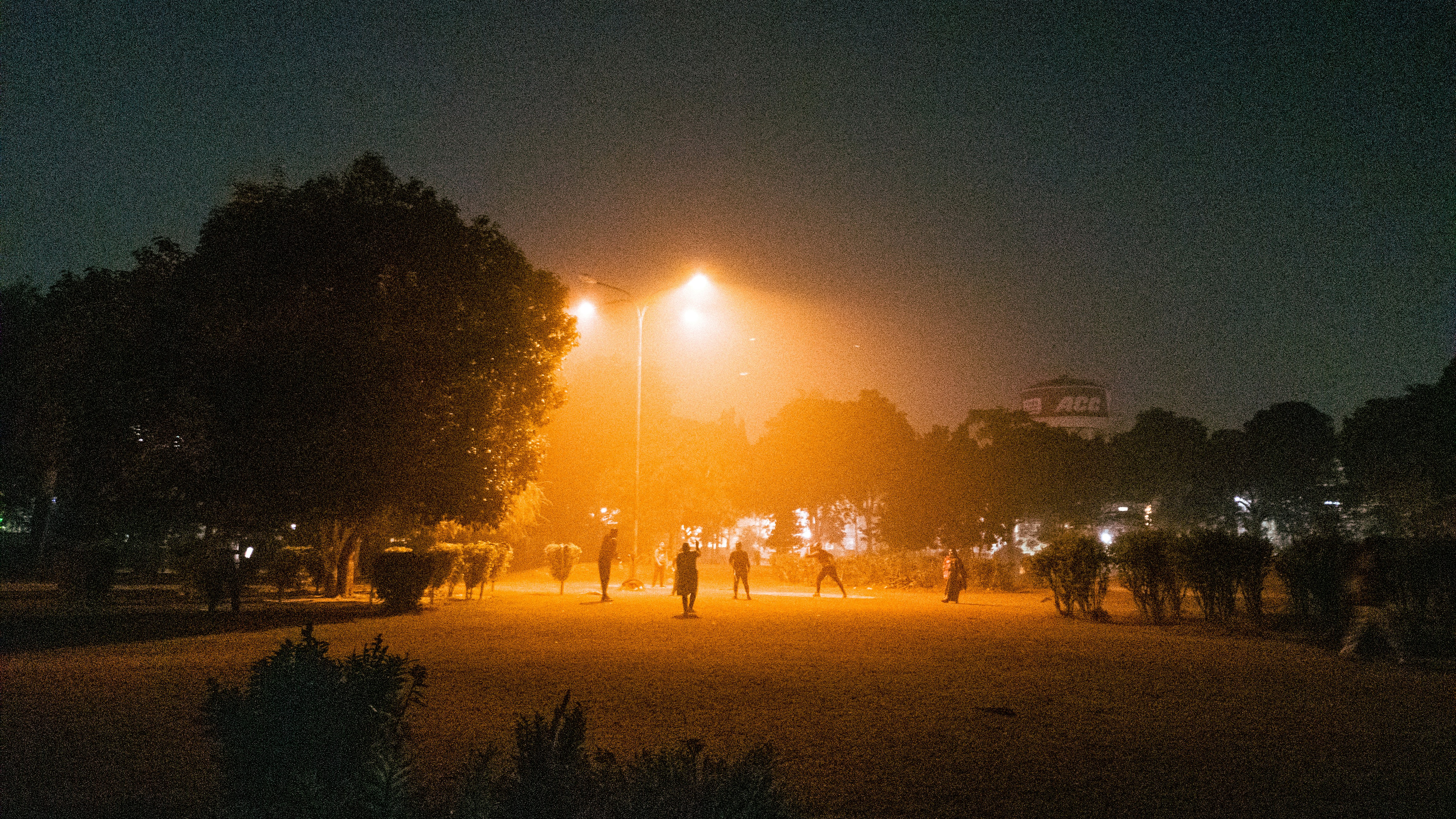 a group of people standing around a park at night