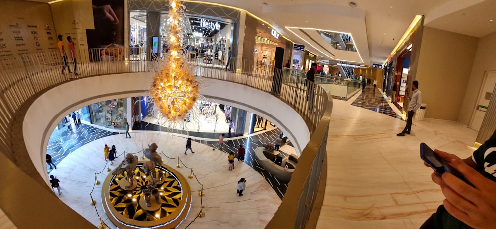 a person taking a picture of a chandelier in a mall