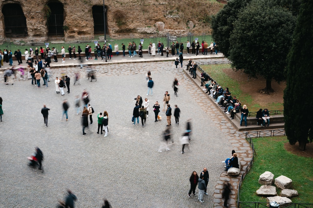 a crowd of people walking around a stone courtyard