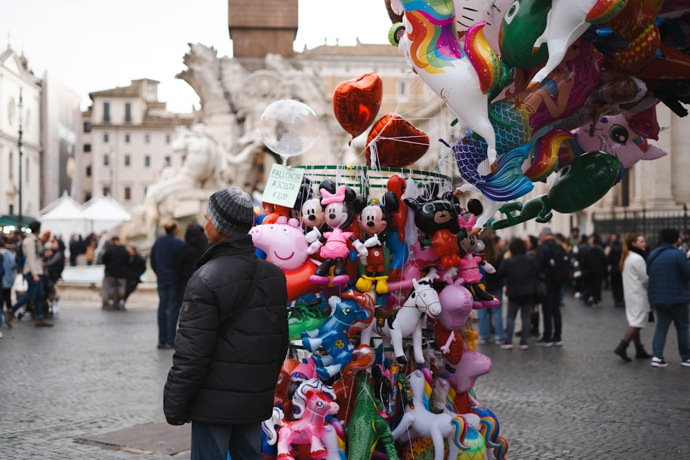 a man standing next to a display of stuffed animals