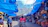 A woman inspecting a large blue tarpaulin covering a market stall in Africa.