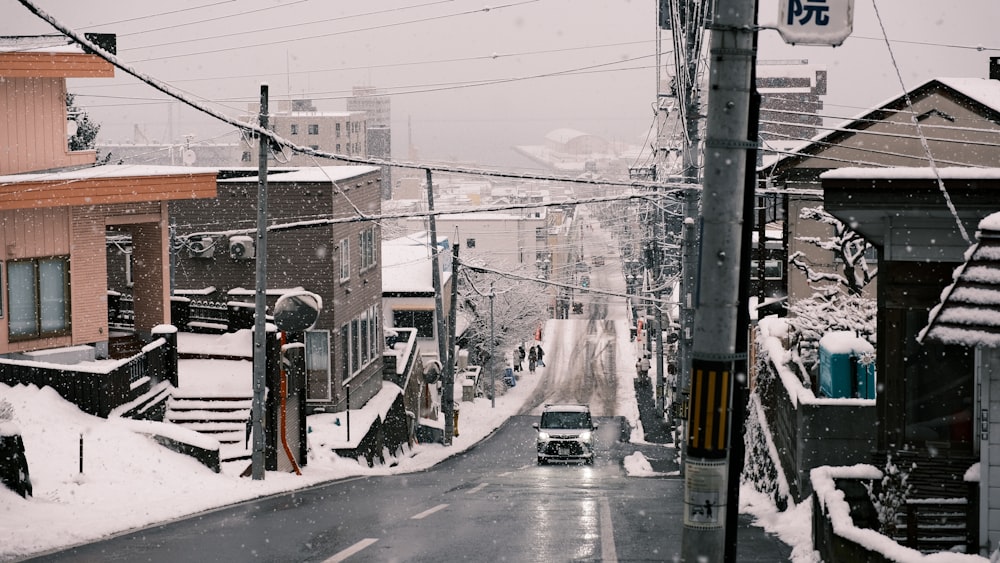 a car driving down a snow covered street