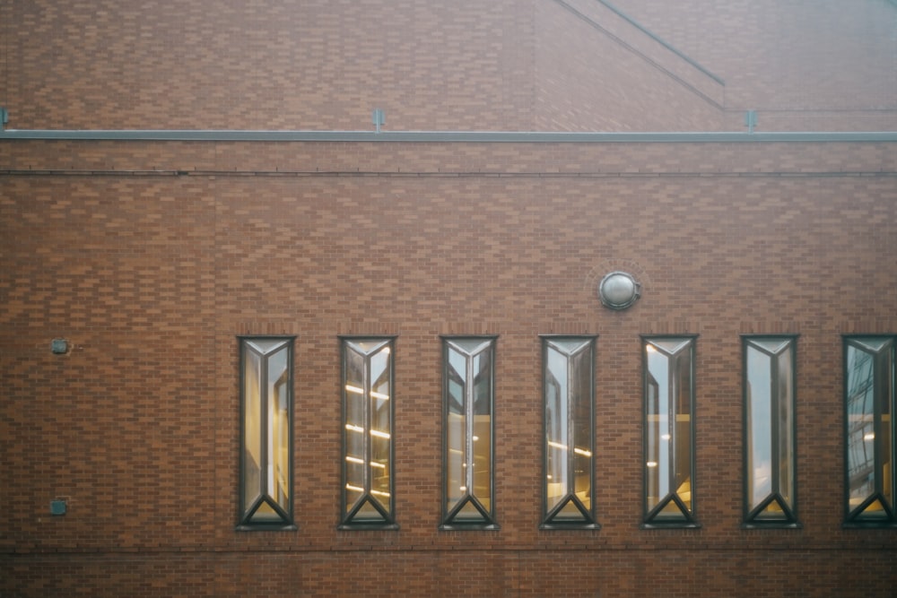 a brick building with windows and a clock on the side