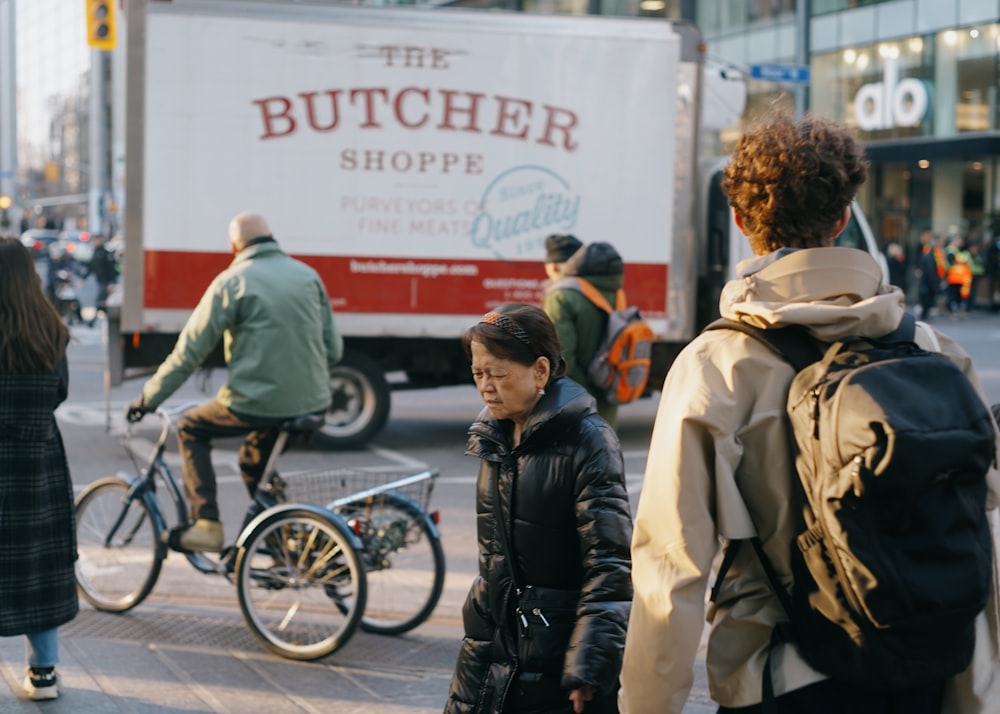 a group of people walking down a street next to a truck