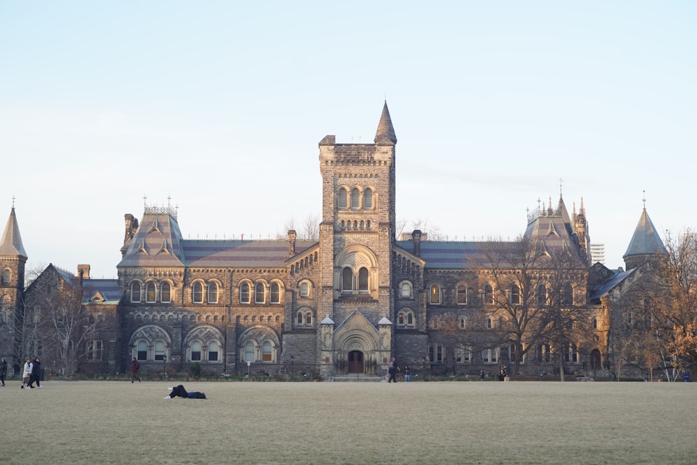a large building with a clock tower in the middle of a field