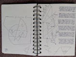 Open notebook showing pages with subtle esoteric illustrations in black and white.