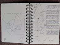An open notebook filled with handwritten notes and sketches about cosmic patterns.