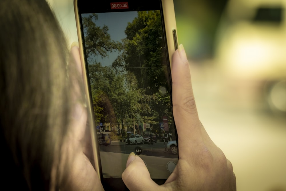 a person taking a picture of a street with a cell phone