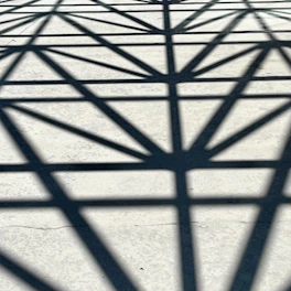 abstract geometric shadows cast on brutalist concrete, fractured by violet light