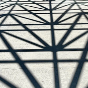 abstract geometric shadows cast on brutalist concrete, fractured by violet light