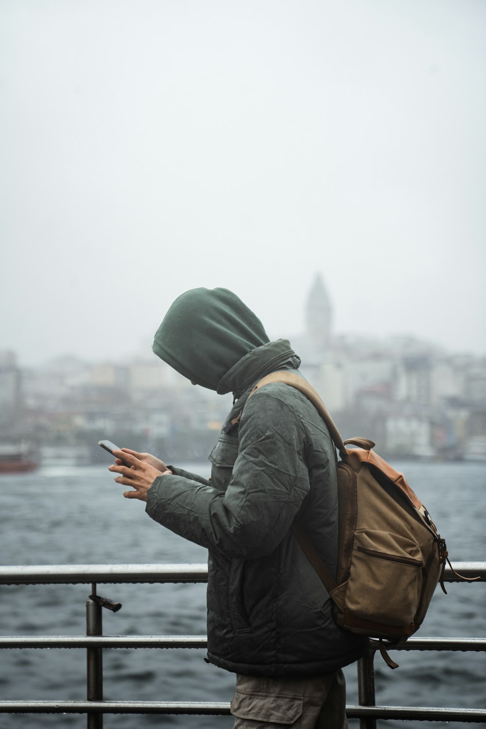 Ein Mann mit einem Rucksack, der auf sein Handy schaut