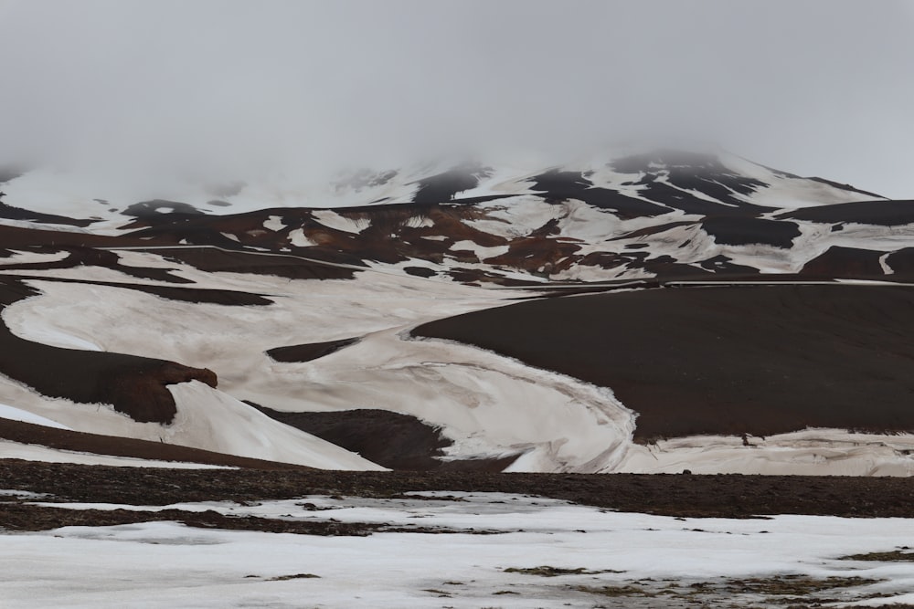 a mountain covered in snow with a cloud in the sky