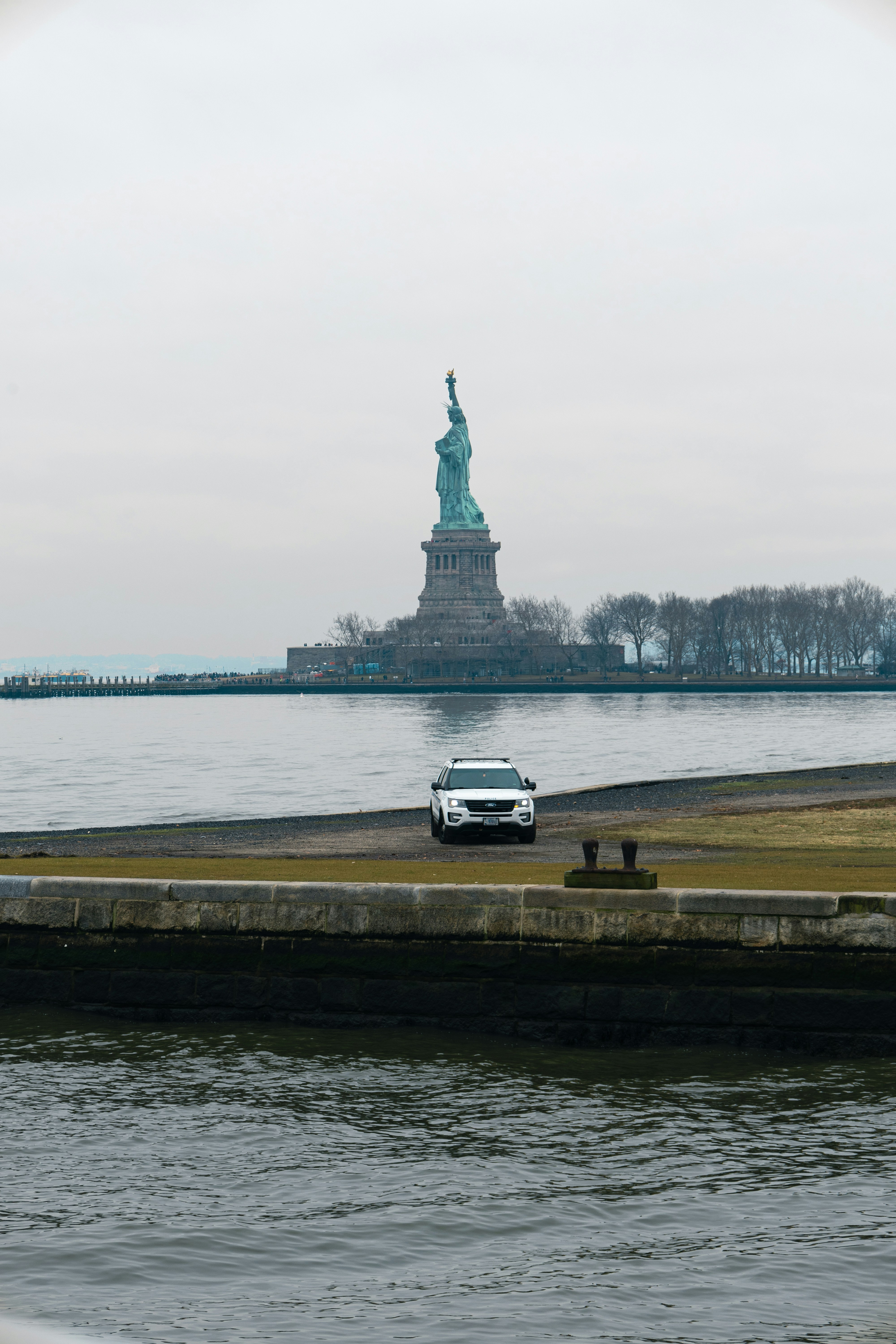 a car parked in front of the statue of liberty