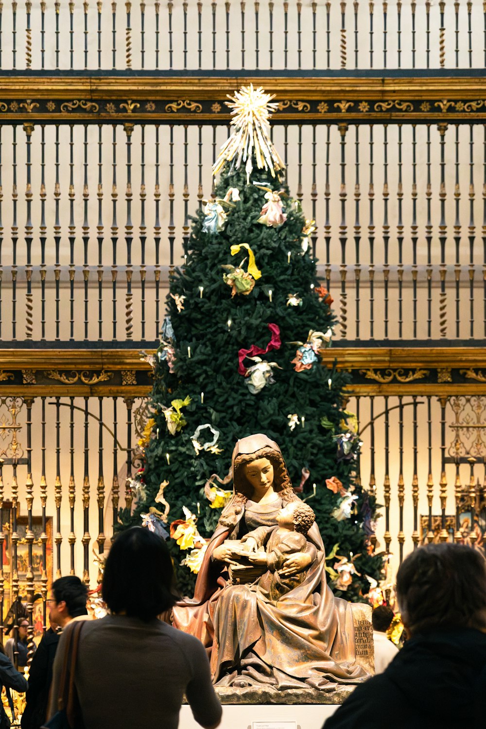 a christmas tree with a statue of a woman in front of it