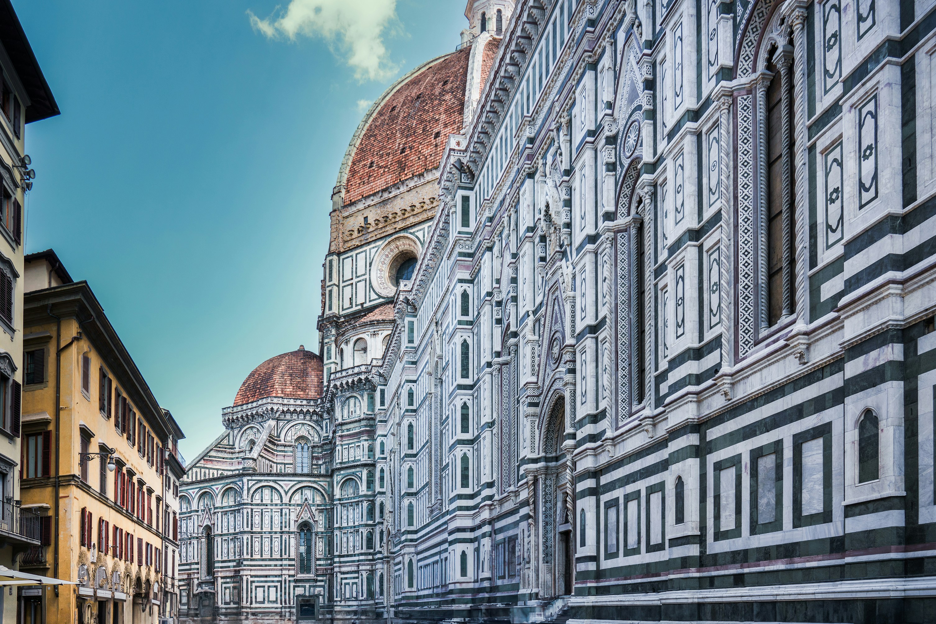 a row of buildings with a blue sky in the background, Florence city center. A fragment of the urban development. Mediterranean architecture. Holiday destination. Santa maria del fiore.