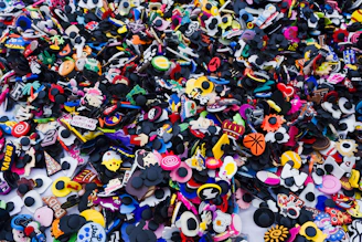 Close-up of colorful Crocs shoe charms attached to a pair of white Crocs.