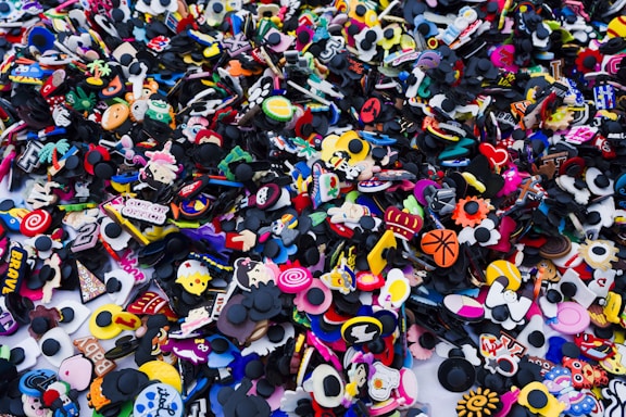 A colorful display of various shoe charms arranged on a bright background.