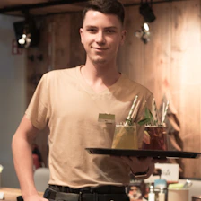 Waiter delivering a tray with tropical drinks and fresh food to a guest’s room.