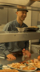 A smiling technician consulting with a restaurant owner about kitchen equipment.