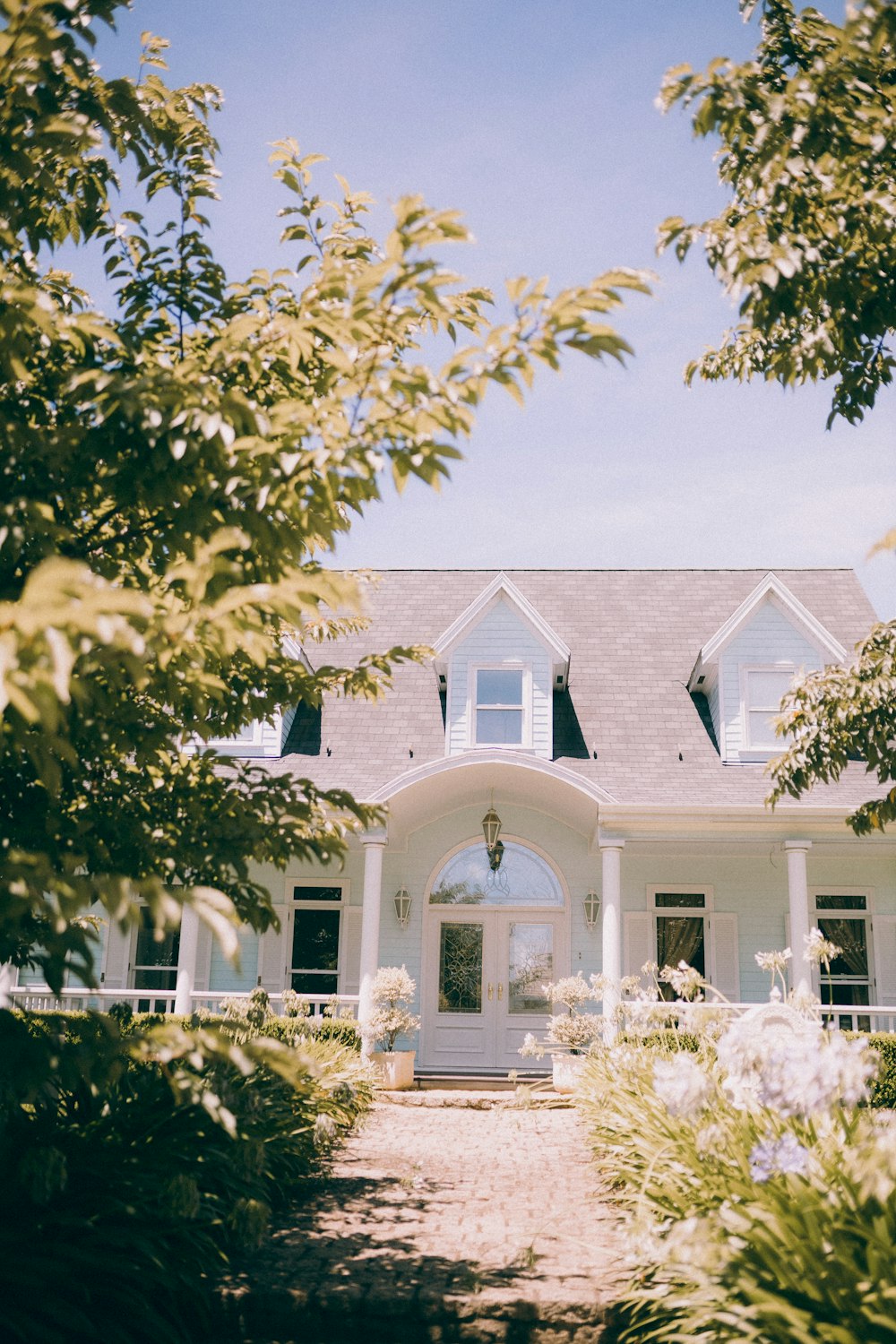 a white house surrounded by trees and bushes