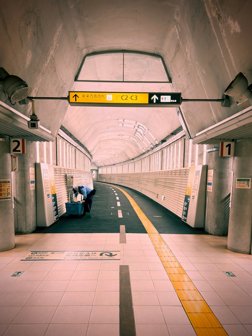 a train station with a person sitting on a bench