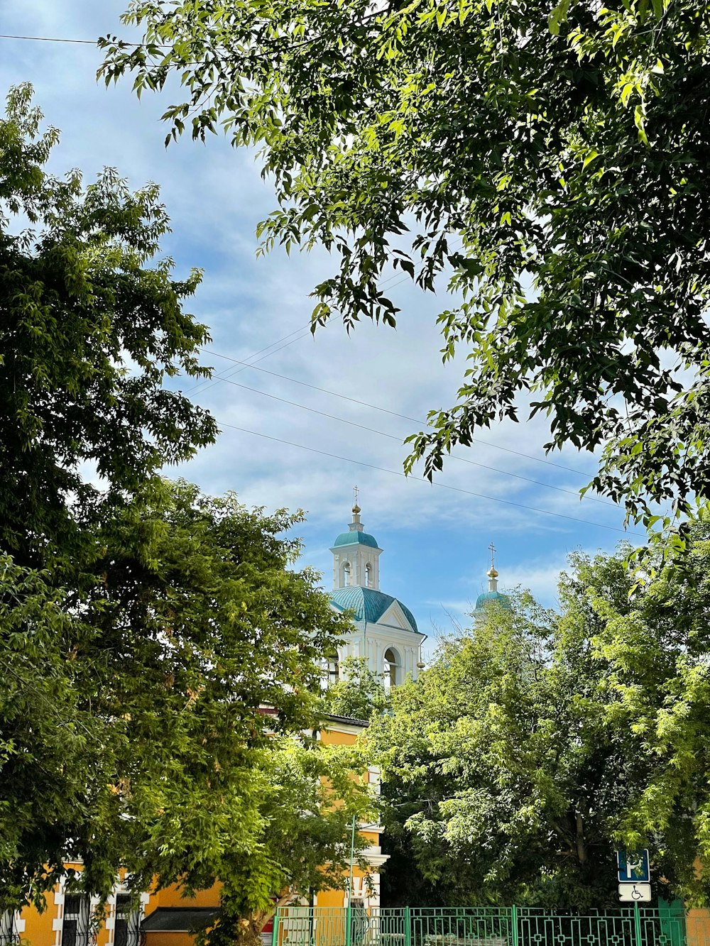 a church with a steeple surrounded by trees