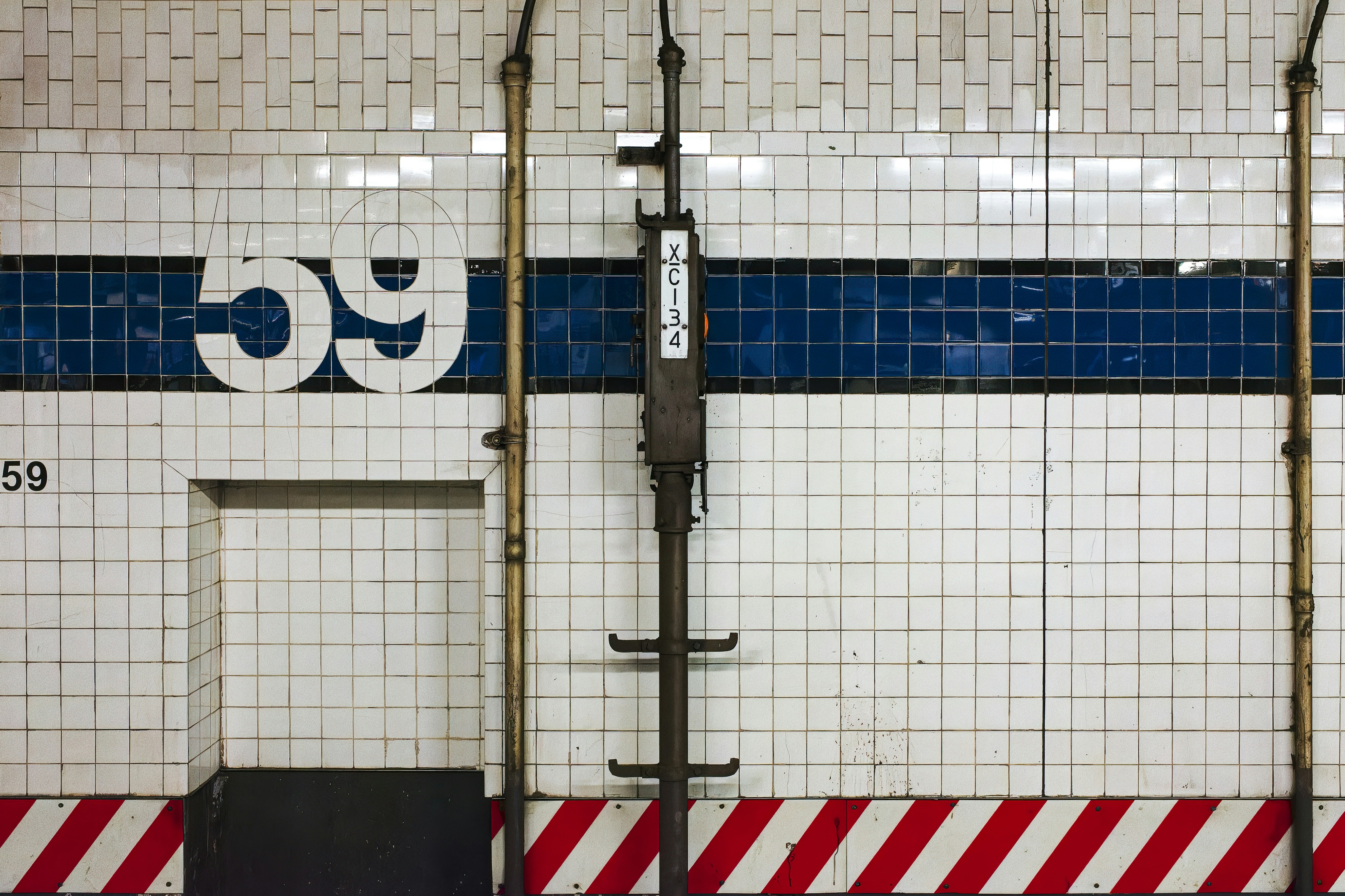 a blue and white tiled wall next to a door