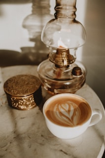 a cappuccino on a saucer next to a glass jar