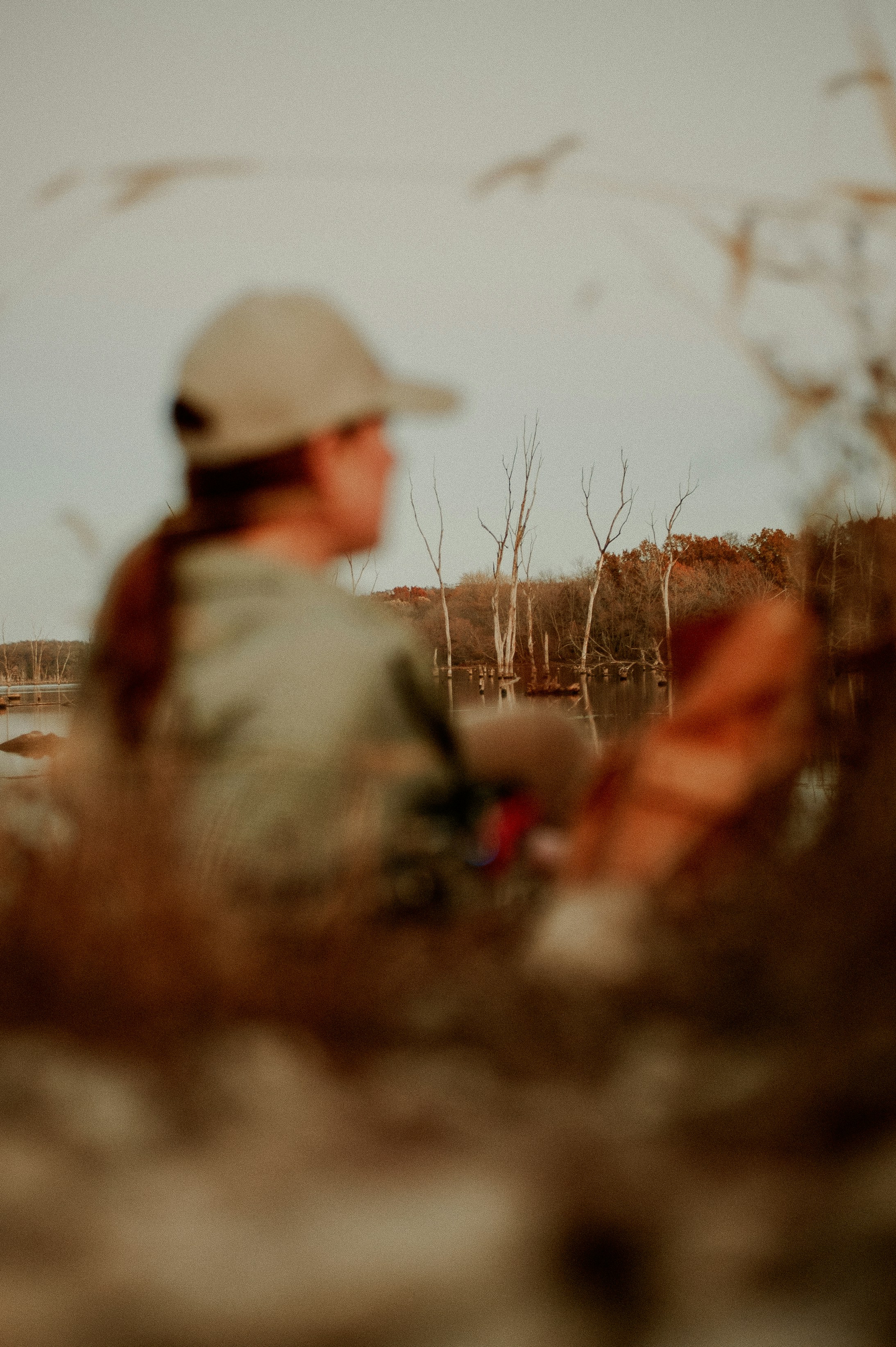 a man in a hat sitting in a field