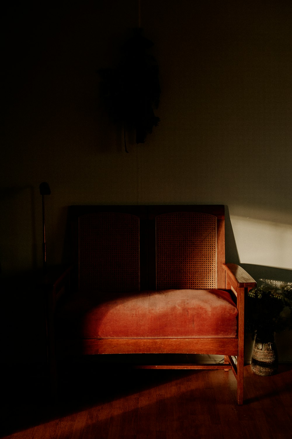 木製の床の上に座る赤いソファ