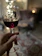 A happy customer holding a glass of red wine in a cozy home setting.