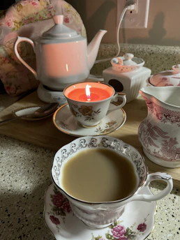 A cozy tea setup with steaming cups and fresh herbs on a cream-colored cloth.
