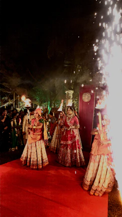 Festive occasion scene with women dressed in vibrant sarees and designer blouses, sparkling under warm lighting.