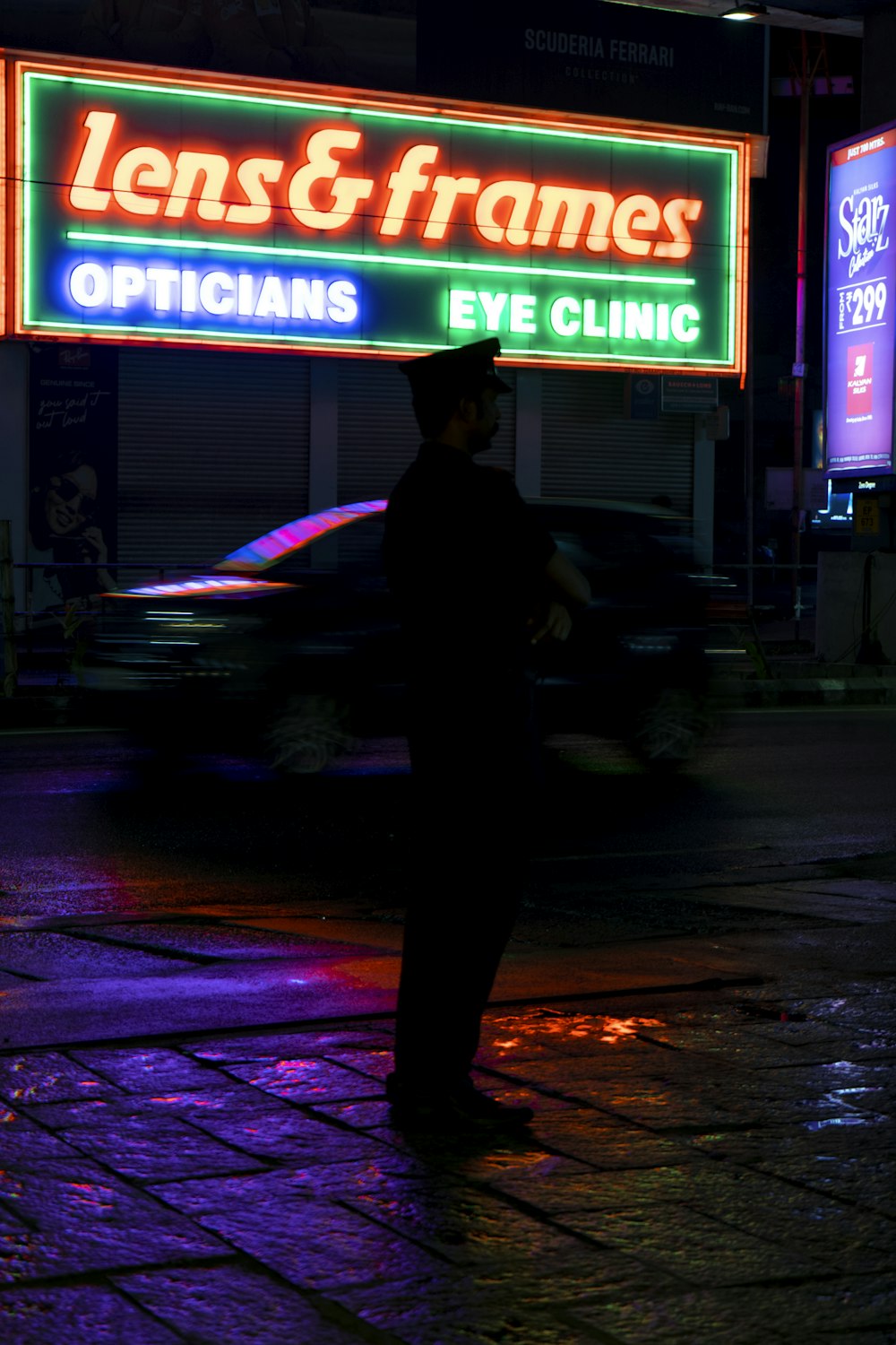 a man standing on a sidewalk in front of a neon sign