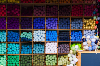 A colorful display of vibrant yarns and knitting supplies arranged on a wooden table.