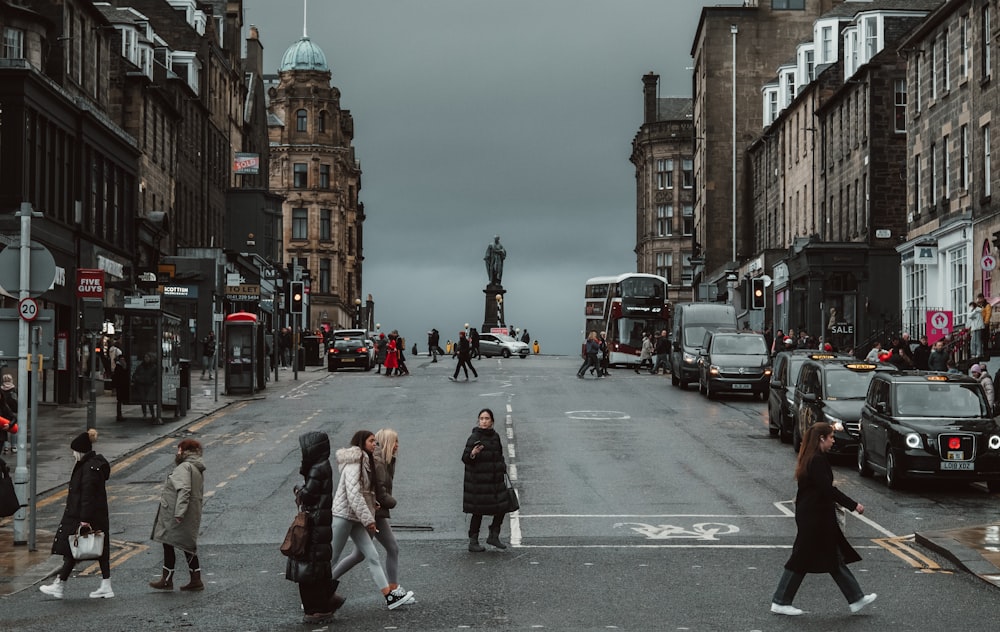 a group of people crossing a street in a city