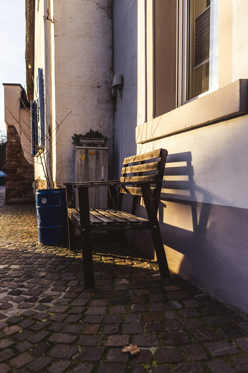 a wooden bench sitting next to a building