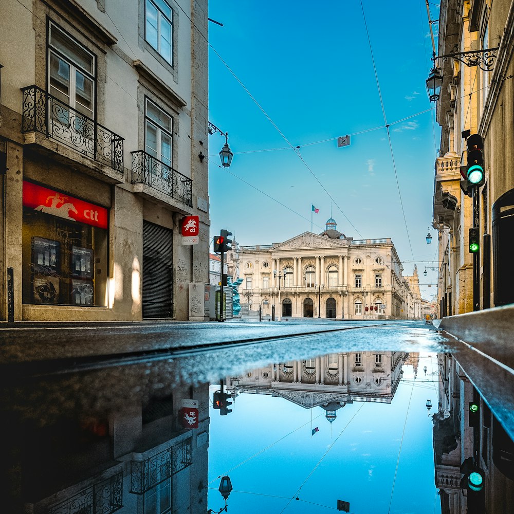 a reflection of a building in a puddle of water