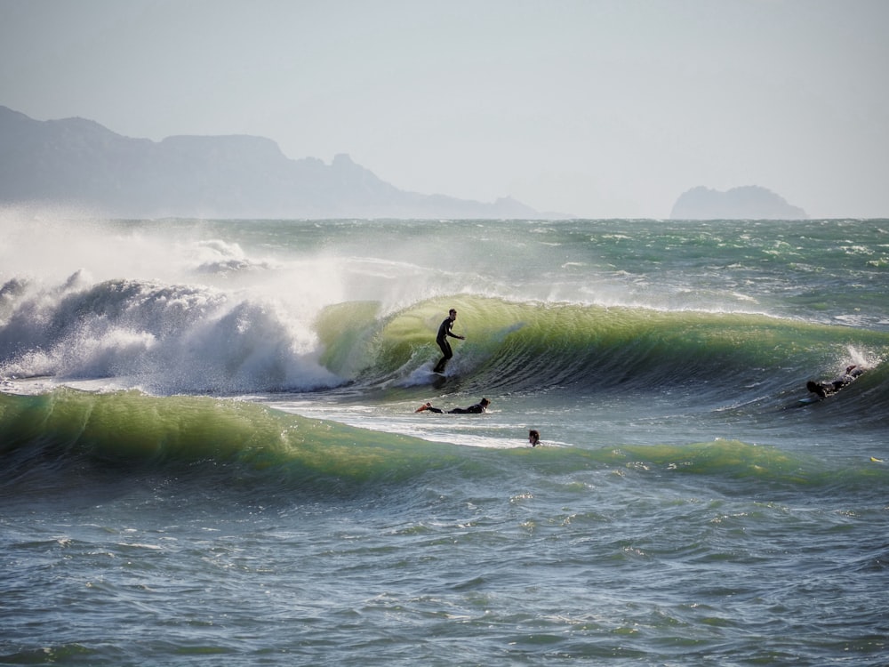 a man riding a wave on top of a surfboard