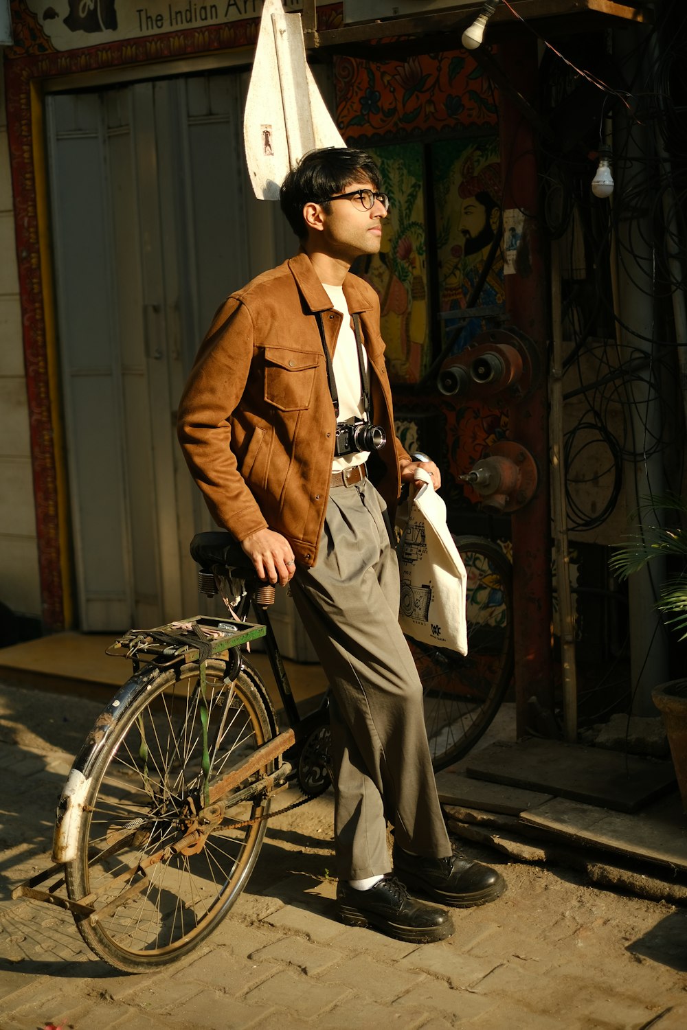 a man standing next to a bike on a sidewalk