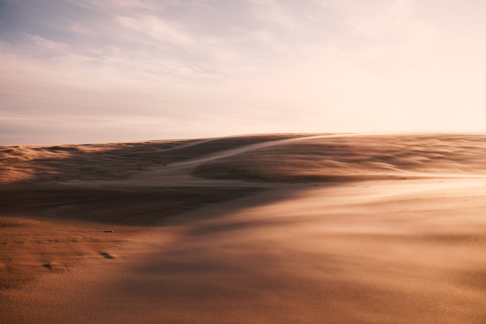 a sand dune with a sky in the background