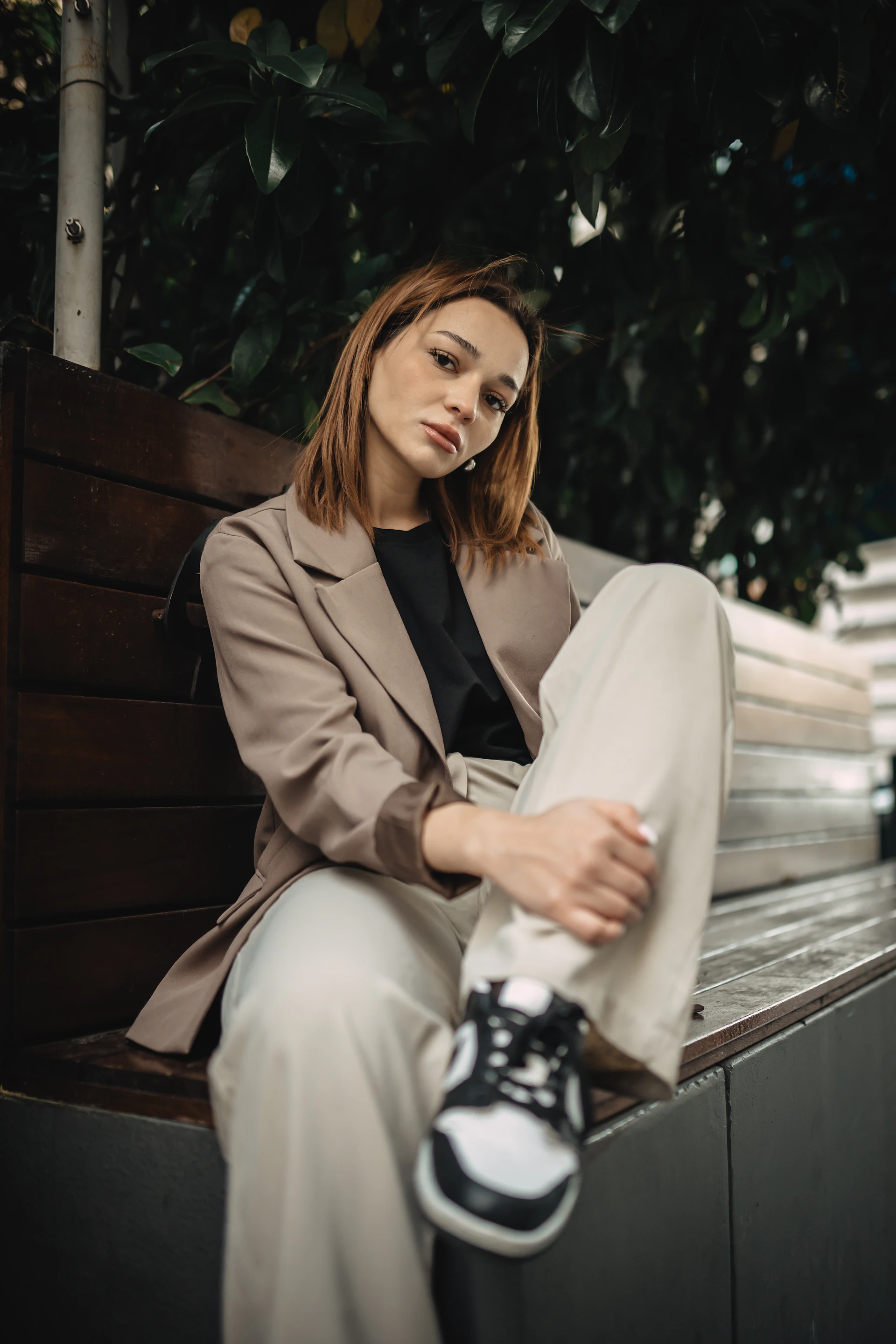 a woman sitting on top of a wooden bench