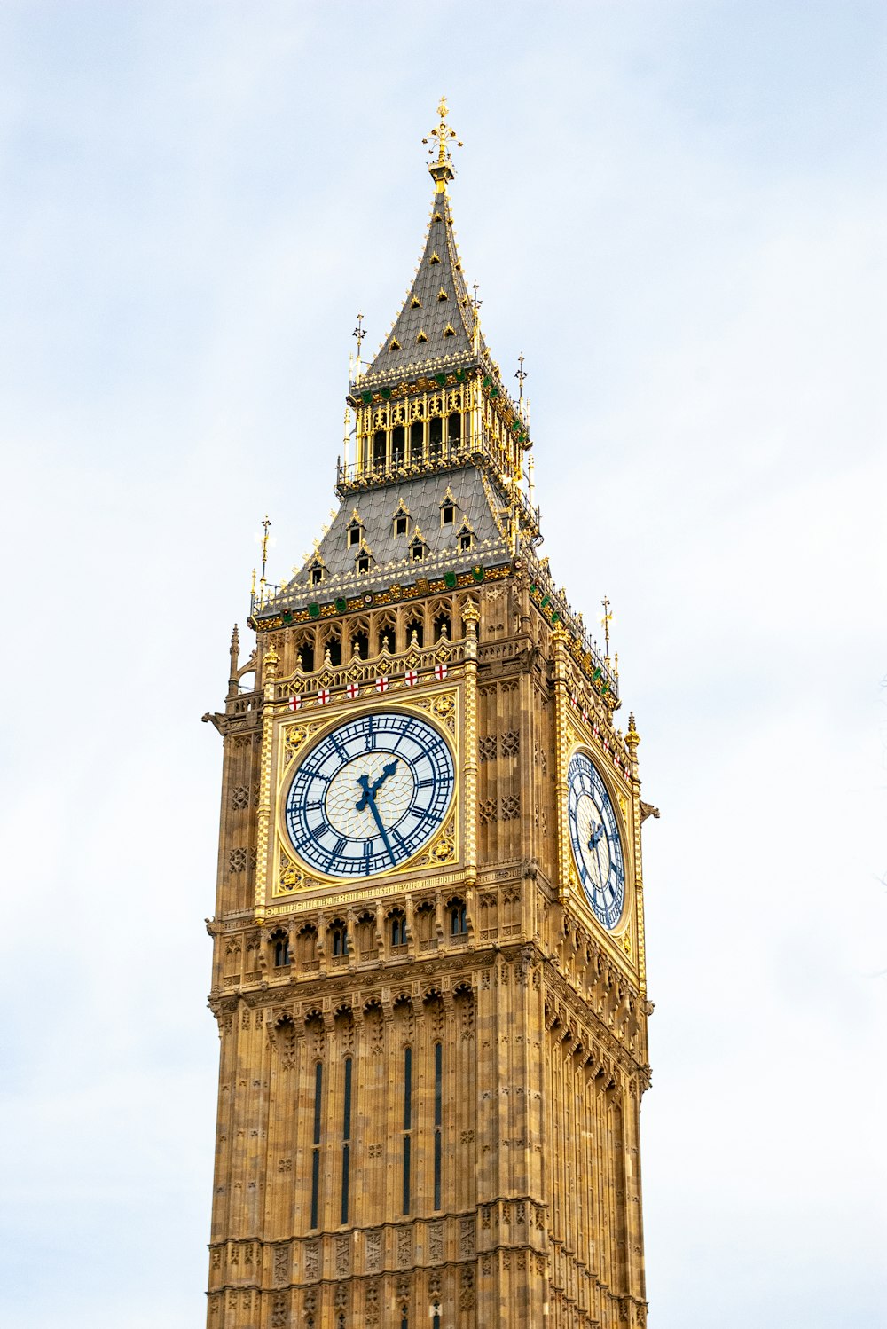 un'alta torre dell'orologio con uno sfondo di cielo