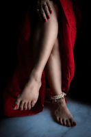 Elegant feet with a fresh pedicure featuring a classic red polish and delicate nail art.